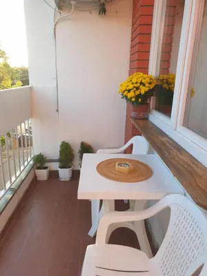 a white table and two white chairs on a balcony at Despot Apartmani Niš in Niš