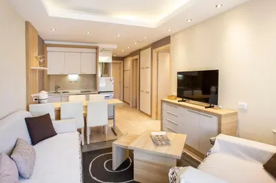 a living room and kitchen with a couch and a table at kopaonik konaci centar lux apartman in Kopaonik