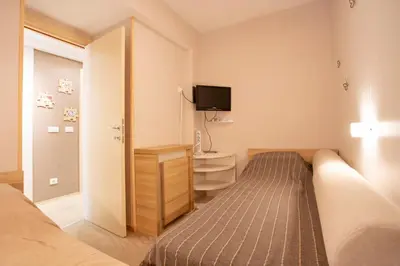 a bedroom with a bed and a desk and a tv at kopaonik konaci centar lux apartman in Kopaonik