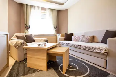 a living room with a couch and a table at kopaonik konaci centar lux apartman in Kopaonik