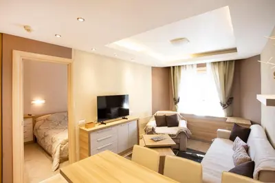 a living room with a couch and a bed at kopaonik konaci centar lux apartman in Kopaonik