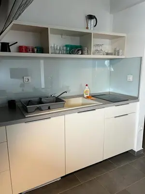 a kitchen with white cabinets and a sink at Vučko apartmani Konaci in Kopaonik
