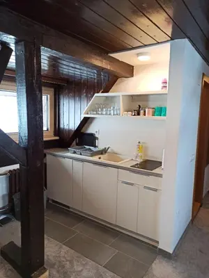 a kitchen with white cabinets and a sink at Vučko apartmani Konaci in Kopaonik