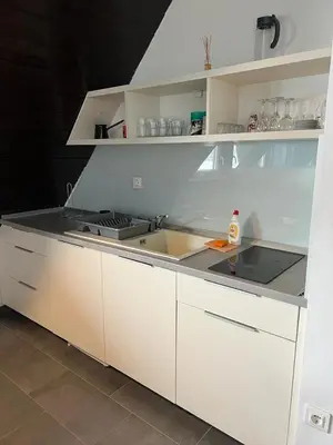 a kitchen with white cabinets and a sink at Vučko apartmani Konaci in Kopaonik