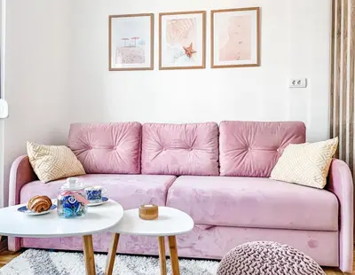 a pink couch in a living room with a table at Apartment Atria II in Vrnjačka Banja