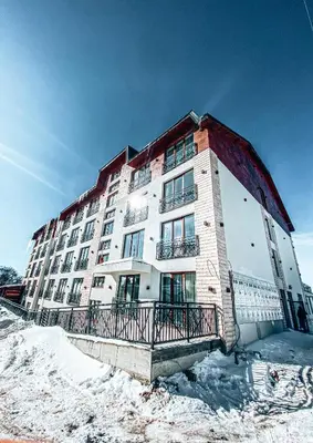 a large apartment building with snow on the ground at President Kop A410 in Kopaonik