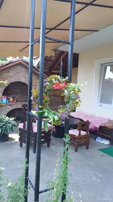 a patio with a bunch of flowers and a bed at Apartman ''Nena,, in Soko Banja