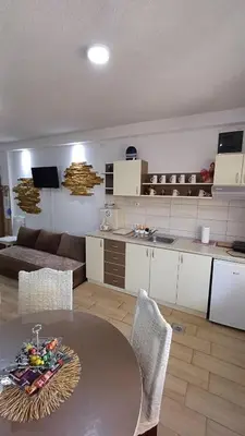 a kitchen and a living room with a table at Apartman ''Nena,, in Soko Banja