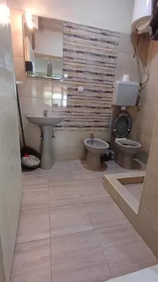a bathroom with two sinks and a toilet and a mirror at Apartman ''Nena,, in Soko Banja