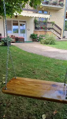 a wooden swing in the yard of a house at Apartman ''Nena,, in Soko Banja