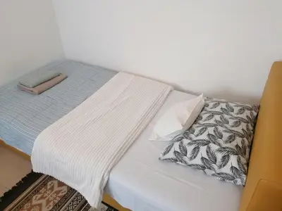 a bed with a white blanket and pillows on it at Apartman Centar 2 in Kruševac