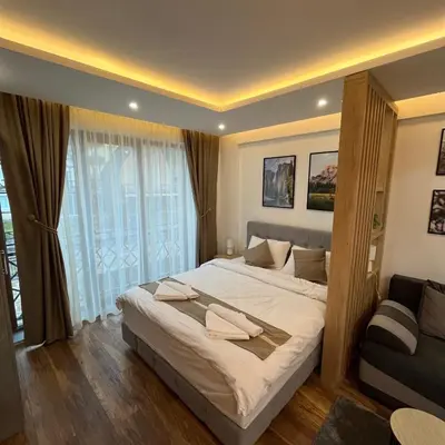 a bedroom with a large bed and a couch at President Kop - Silver Ice Apartment in Kopaonik