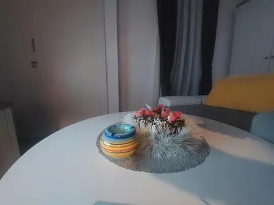 a table with a colorful bowl and flowers on it at Apartman Milly in Kopaonik