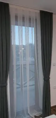 a window with green and white curtains in a room at Apartman Milly in Kopaonik