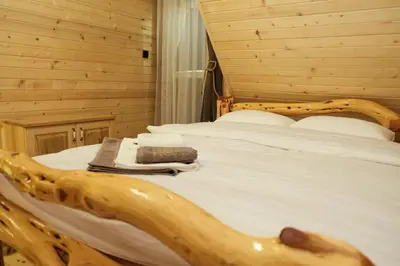 a bedroom with a log bed with a book on it at Drvena Kuca RUŽA in Kopaonik