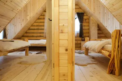 a bedroom in a log cabin with two beds at Drvena Kuca RUŽA in Kopaonik