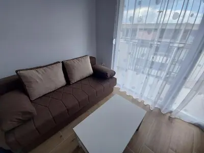 a brown couch in a living room with a window at Ekskluziv apartmani in Paraćin