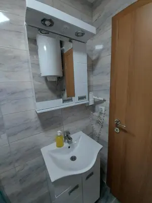 a bathroom with a sink and a mirror at Ekskluziv apartmani in Paraćin