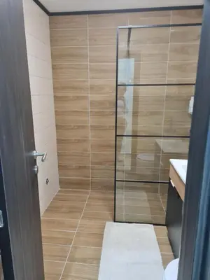 a shower with a glass door in a bathroom at SWAN Kopaonik in Kopaonik