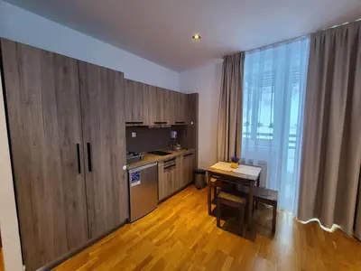 a kitchen with wooden cabinets and a table and a desk at Bela Brada - Brzeće, Kopaonik in Brzeće