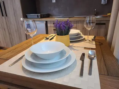 a table with plates and bowls and wine glasses at Bela Brada - Brzeće, Kopaonik in Brzeće