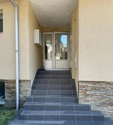 a set of stairs leading to a door of a building at Apartman Nice in Vrnjačka Banja