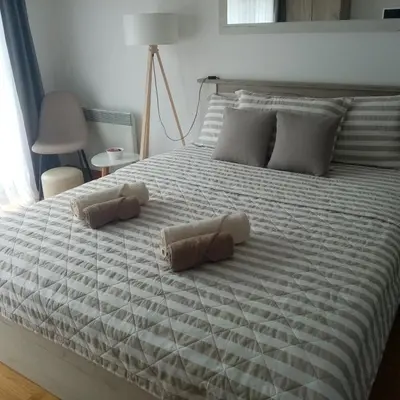 a large white bed with two pillows on it at Apartman Nice in Vrnjačka Banja