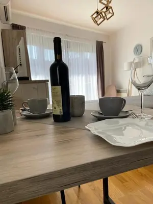 a bottle of wine sitting on top of a wooden table at Apartman Nice in Vrnjačka Banja