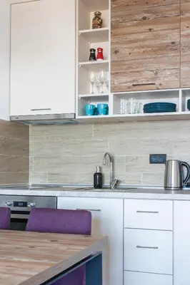 a kitchen with white cabinets and purple chairs at Sunset View Ski & Spa apartments Kopaonik in Kopaonik