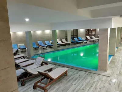 a pool in a hotel with lounge chairs and a pool at Sunset View Ski & Spa apartments Kopaonik in Kopaonik