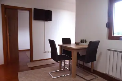 a room with a table with chairs and a television at Apartman Kentaur Vrnjačka Banja in Vrnjačka Banja