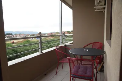 a balcony with a table and chairs and a view at Apartman Kentaur Vrnjačka Banja in Vrnjačka Banja