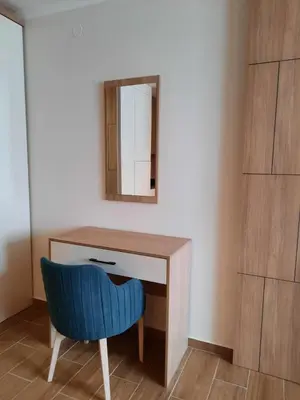 a blue chair sitting next to a desk with a mirror at Apartman Radmila in Kopaonik