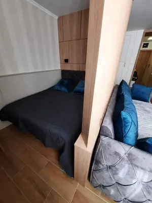 a bedroom with a bed with blue pillows at Apartman Radmila in Kopaonik