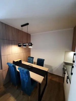 a dining room with a table and blue chairs at Apartman Radmila in Kopaonik
