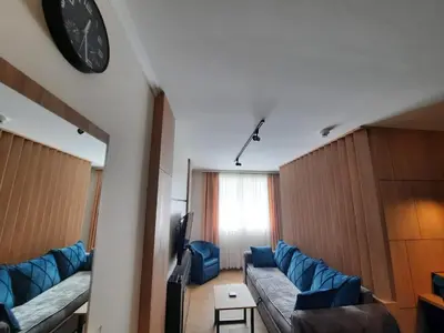a living room with a couch and a clock on the wall at Apartman Radmila in Kopaonik