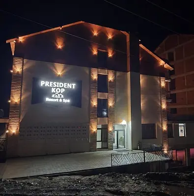 a building with a sign on the side of it at night at Apartment Sun - President Kop A512 in Kopaonik