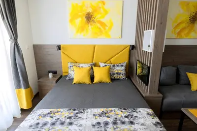 a bedroom with a bed with a yellow headboard and yellow pillows at Apartment Sun - President Kop A512 in Kopaonik