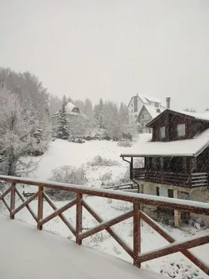 a snow covered yard with a house and a fence at Kraljevi Cardaci 9D 12- Sunny view in Kopaonik