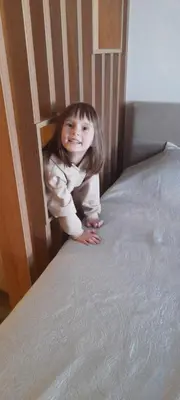 a little girl is crawling on a bed at Milmari N80, Kopaonik in Raška