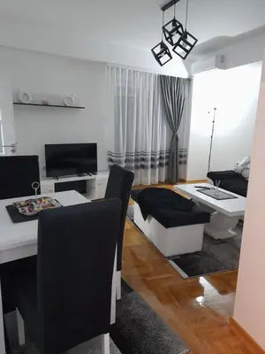 a living room with a table and a couch at Holiday apartments in Niš