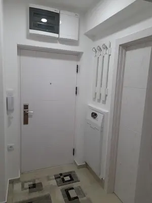 a white room with a door with a microwave above it at Holiday apartments in Niš