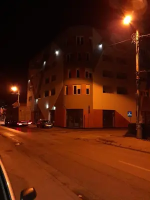 a building on the side of a street at night at Holiday apartments in Niš