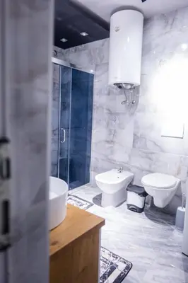 a bathroom with a sink and a toilet and a shower at Apartmani Đorđević in Soko Banja
