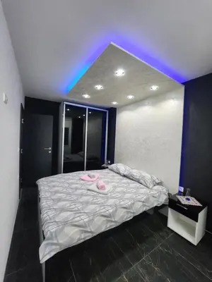 a bedroom with a large bed with a purple light at Apartmani Đorđević in Soko Banja