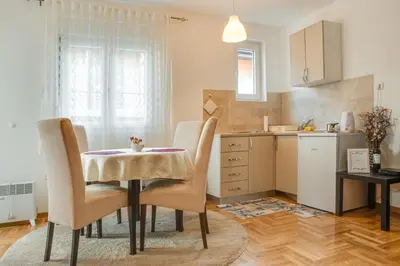 a kitchen and dining room with a table and chairs at Apartment Joy by Central in Vrnjačka Banja