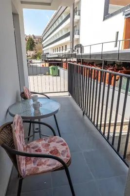 a patio with a table and chairs on a balcony at Apartment Joy by Central in Vrnjačka Banja
