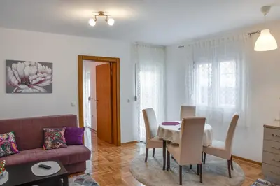 a living room with a table and a couch at Apartment Joy by Central in Vrnjačka Banja