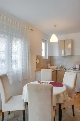 a kitchen and dining room with a table and chairs at Apartment Joy by Central in Vrnjačka Banja