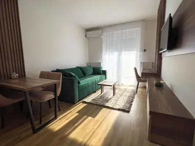 a living room with a green couch and a table at Hany Sweet in Niš